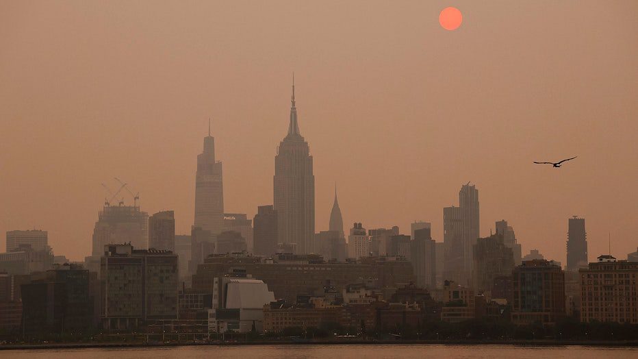 Viewed from Jersey City, New Jersey, the sun rises behind a hazy, smoky sky on June 6, 2023. (Photo by Gary Hershorn/Getty Images)
